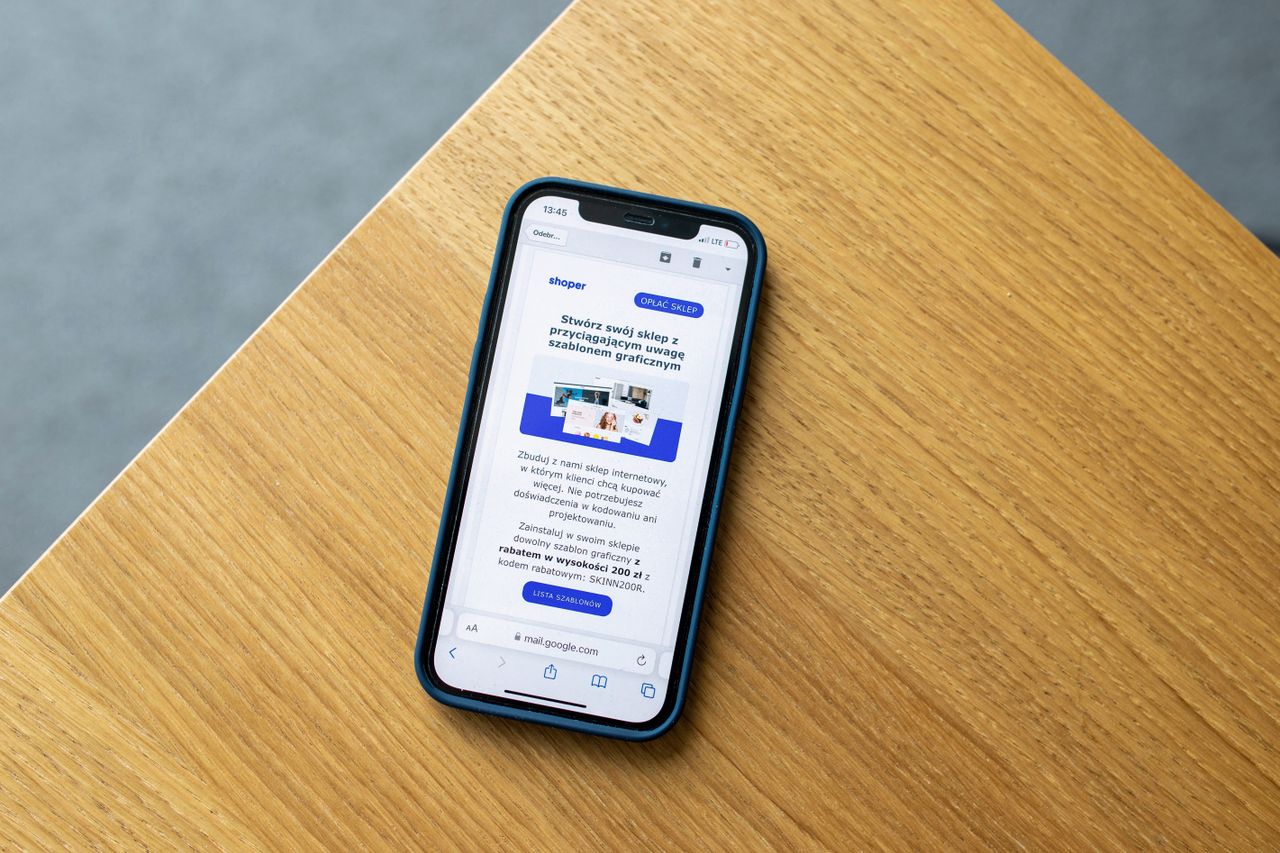 Téléphone mobile affichant une interface de commerce en ligne, posé sur une surface en bois, illustrant la technologie d’achat sur Internet.